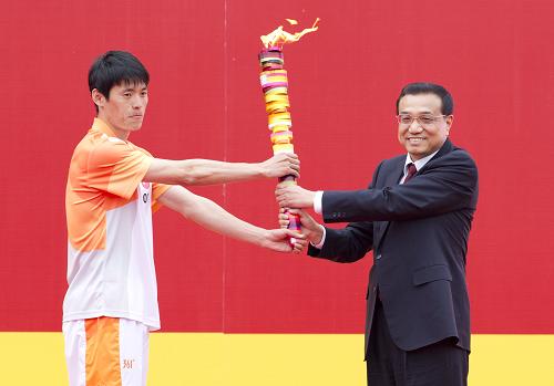 5月4日,深圳第26屆世界大學(xué)生夏季運動會火炬點燃暨火炬?zhèn)鬟f活動啟動儀式在北京大學(xué)舉行。這是中共中央政治局常委、國務(wù)院副總理李克強將點燃的火炬交給第一棒火炬手。新華社記者 王曄 攝