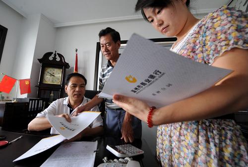 創(chuàng)辦過(guò)新中國(guó)首家私人錢(qián)莊的浙江溫州民間金融家、溫州方興擔(dān)保公司董事長(zhǎng)方培林(左)和公司同事商討融資業(yè)務(wù)(7月6日攝)。新華社記者 韓傳號(hào) 攝