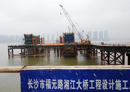 長沙福元路湘江大橋施工現(xiàn)場(7月12日攝)。近日,長沙市福元路湘江大橋全面進(jìn)入主橋鋼拱梁頂推施工階段。據(jù)介紹,長沙福元路湘江大橋全長約3575米,其中越江段約1435米。橋梁主跨寬達(dá)38米,按雙向六車道城市主干路設(shè)計,并設(shè)置有雙向人行道。目前,大橋首個主拱開始拼裝,預(yù)計到9月中旬拼裝完畢,明年6月實現(xiàn)主橋合龍。新華社記者 龍弘濤 攝