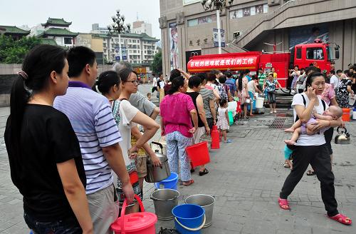 7月27日,綿陽市民在綿陽消防支隊送水點排隊打水。從7月26日晚開始,綿陽消防支隊組織力量為群眾送水,目前已出動48車次,為各單位、社區(qū)居民點等送水375噸,以解燃眉之急。新華社發(fā)(王二來攝)