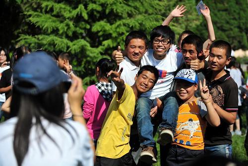 8月2日,臨行前一名臺(tái)灣支教大學(xué)生(中)被蘭州市第二十四中學(xué)的學(xué)生們抬起合影留念。當(dāng)日,由來自臺(tái)灣新竹清華大學(xué)、“中央大學(xué)”、交通大學(xué)、陽明大學(xué)4所高校的28名師生組成的志工團(tuán)隊(duì)結(jié)束在甘肅省蘭州市紅古區(qū)第二十四中學(xué)為期10天的支教工作。蘭州市第二十四中學(xué)是“千鄉(xiāng)萬才計(jì)劃”西部故事助學(xué)金項(xiàng)目的會(huì)員學(xué)校之一,今年第一次與臺(tái)灣高校學(xué)生直接交流。“千鄉(xiāng)萬才計(jì)劃”系臺(tái)灣已故企業(yè)家溫世仁搭建的一個(gè)促進(jìn)兩岸交流、幫扶貧困生、改變西部地區(qū)落后面貌的平臺(tái),而西部故事助學(xué)金項(xiàng)目是“千鄉(xiāng)萬才計(jì)劃”中的一個(gè)重要組成部分。目前,“千鄉(xiāng)萬才計(jì)劃”通過西部故事項(xiàng)目已吸引到大量捐贈(zèng)。現(xiàn)在在甘肅省蘭州市紅古區(qū)的西部故事會(huì)員學(xué)校有5所,受益學(xué)生達(dá)150多人次。新華社記者 張錳 攝