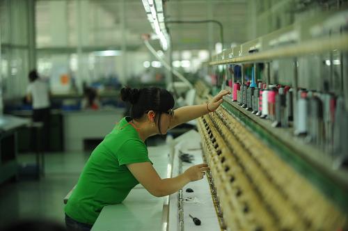 一名女工在對運動鞋進行電腦刺繡(攝于6月14日)。江西鄱陽縣裕泰鞋業(yè)是由臺商在江西投資建成的全江西省最大的制鞋基地。原本在廣東的工廠轉(zhuǎn)移到江西后,解決了當?shù)貏趧恿蜆I(yè)。近年來由于勞動力成本上升、資源緊缺等因素,越來越多勞動力密集產(chǎn)業(yè)選擇由東部沿海地區(qū)向中西部轉(zhuǎn)移。新華社記者 周密 攝
