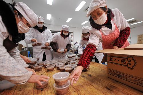 1月17日,杭州靈隱寺內(nèi)的義工在把臘八粥裝箱。新華社記者 黃宗治 攝