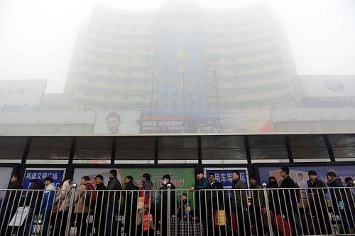 1月31日,在濟(jì)南火車站,旅客在霧霾中排隊(duì)等待乘坐出租車。新華社記者 郭緒雷 攝
