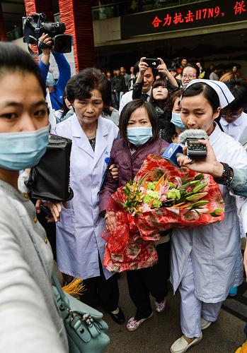 4月19日,治愈患者賈某(前中)在醫(yī)護(hù)人員及親屬的陪同下出院。新華社記者 徐昱 攝