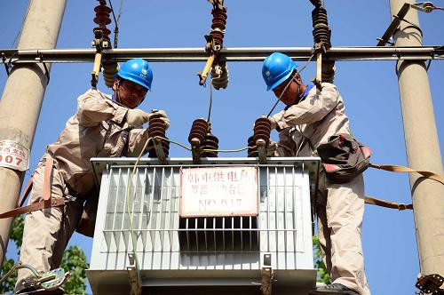 5月13日,國(guó)家電網(wǎng)茌平供電公司的工作人員在進(jìn)行增容改造作業(yè)。新華社記者 郭緒雷 攝