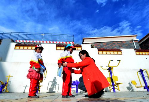 5月13日,玉樹八一孤兒學校的老師卓瑪永措在給低年級的孩子整理衣服。在青海玉樹州八一孤兒學校,323名學生和57名教職工共同組建了一個溫暖的大家庭。這里的老師既傳道解惑,又像父母,他們和孩子們一起生活、學習,營造著其樂融融的“家”。新華社記者 王博 攝