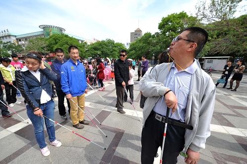 5月14日,在寧夏銀川市玉皇閣廣場上,帶隊進行定向行走的盲人通過哨音引導其他盲人進行定向行走。新華社記者 彭昭之 攝