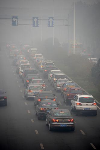 10月21日,哈爾濱市部分路段能見(jiàn)度不足50米,車(chē)輛在霧霾中緩慢前行。新華社記者 王凱 攝