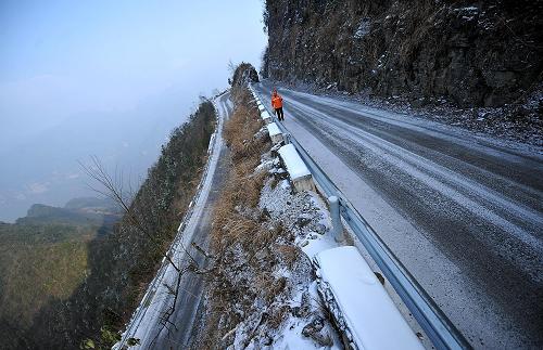 一名養(yǎng)路工人在雪天堅守在通往“恩施屋脊”——平均海拔1800米的湖北省宣恩縣椿木營鄉(xiāng)的公路上(2011年12月31日攝)。 新華社發(fā)(宋文 攝)