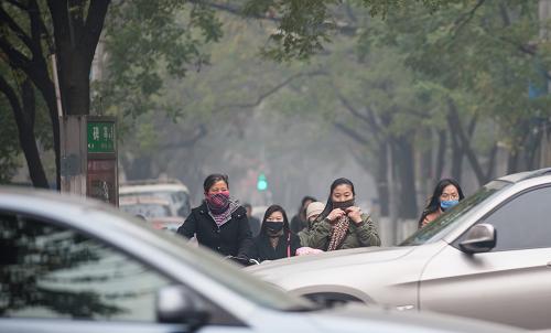 12月5日,南京市市區(qū)碑亭巷路口,幾名戴口罩的行人在等信號燈。新華社發(fā)(李響 攝)