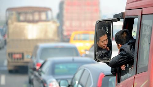 車輛滯留在南昌昌東高速路入口處,一名司機(jī)在車上等待通行(12月5日攝)。新華社記者 周科 攝