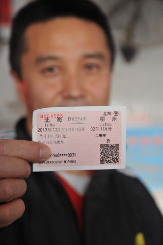 12月26日,在廣西北?;疖囌荆幻每驼故舅麆傎彽玫膭?dòng)車車票。新華社發(fā)(李君光 攝)