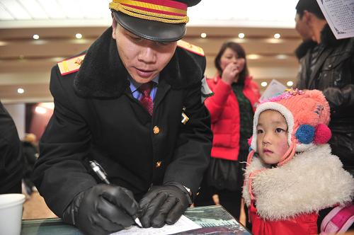 1月16日,在西藏拉薩火車(chē)站,火車(chē)站工作人員在為準(zhǔn)備上車(chē)的乘客填寫(xiě)健康表。新華社記者 劉坤 攝