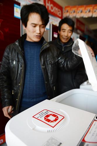 1月20日,寧夏賀蘭縣欣榮村,一位家電銷售商(左)在向一名移民介紹補(bǔ)貼產(chǎn)品。近日,寧夏家電行業(yè)推出“家電專項(xiàng)補(bǔ)貼工程”惠民舉措,首批將惠及34個(gè)移民村的3萬余戶家庭。移民群眾購買十大類家電產(chǎn)品,持家電補(bǔ)貼卡可在銷售價(jià)的基礎(chǔ)上優(yōu)惠10%,其中廚電、小家電優(yōu)惠20%。新華社記者 王鵬 攝
