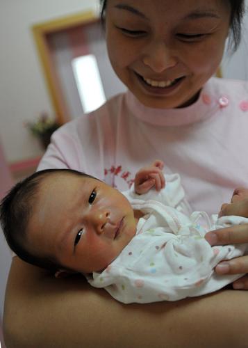 7月12日,桂林市婦幼保健院護(hù)士在護(hù)理一名剛出生的寶寶。新華社記者 陸波岸 攝