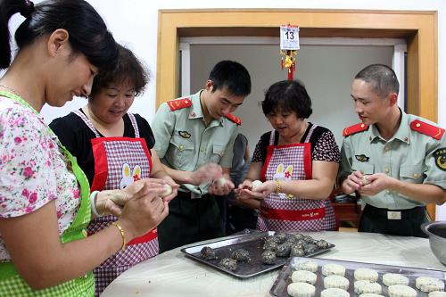 9月13日,在寧波市北侖區(qū)小港鎮(zhèn)陳山社區(qū),來(lái)自四川成都的務(wù)工人員應(yīng)愛蘇(左一)和海警戰(zhàn)士在社區(qū)阿姨的指導(dǎo)下制作月餅。中秋節(jié)臨近,浙江省寧波市北侖區(qū)小港鎮(zhèn)陳山社區(qū)組織轄區(qū)部分不能回家過(guò)中秋節(jié)的外來(lái)務(wù)工人員和浙江海警二支隊(duì)的官兵一起制作月餅,讓遠(yuǎn)在他鄉(xiāng)的親人吃上自己親手做的月餅,給家人寄去一份思念和祝福。新華社發(fā)(索向魯 攝)