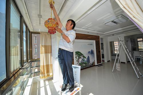 陜西榆林市府谷縣新區(qū)一期經(jīng)濟(jì)適用房住戶王渙清在即將裝修完畢的新房?jī)?nèi)安裝燈飾。陜西省府谷縣從2008年起開始分期分批建設(shè)保障性住房,逐步解決城鎮(zhèn)低收入家庭住房困難。截至目前,該縣已建成保障性住房58.8萬(wàn)平方米、4965套,正在建設(shè)65.3萬(wàn)平方米、5649套。地處毛烏素沙漠南緣和、黃河沿石山區(qū)的陜西省榆林市,歷史上一直是貧窮的代名詞,全市12個(gè)縣區(qū)10年前全為國(guó)家級(jí)貧困縣。隨著煤炭、石油、天然氣等能源的開發(fā)利用,近10年來(lái),榆林市城鄉(xiāng)居民收入不斷提高,人民生活發(fā)生了翻天覆地的變化,逐步由貧困邁進(jìn)小康,神木、府谷兩縣步入全國(guó)百?gòu)?qiáng)縣。目前榆林市城鎮(zhèn)居民收入已由過(guò)去單純依靠工資和離退休金來(lái)增加收入,到現(xiàn)在利息收入、股息與紅利收入、投資收入等多渠道增加收入,經(jīng)營(yíng)凈收入和出租房屋收入快速增長(zhǎng),成為城鎮(zhèn)居民增長(zhǎng)收入的亮點(diǎn),人均可支配收入從10年前的4870元上升到現(xiàn)在的20721元;全市農(nóng)民收入增長(zhǎng)也改變了原來(lái)單純依賴農(nóng)業(yè)“增產(chǎn)增收、減產(chǎn)減收”的模式,形成了以工資性收入、家庭經(jīng)營(yíng)收入為主,財(cái)產(chǎn)性收入和轉(zhuǎn)移性收入多渠道增收的多元化模式,實(shí)現(xiàn)了“減產(chǎn)不減收”的持續(xù)增長(zhǎng)的主動(dòng)增收局面,人均純收入從10年