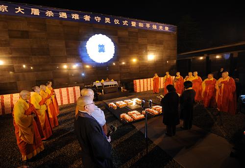12月12日,日本僧侶(中)和中國(guó)僧侶(兩側(cè))為遇難者誦經(jīng)祈禱。新華社記者 孫參 攝