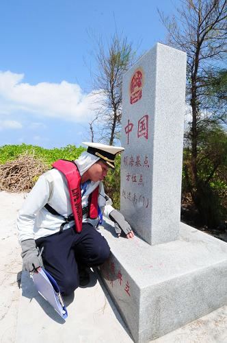 3月10日,中國(guó)海監(jiān)執(zhí)法人員在趙述島勘查領(lǐng)?;c(diǎn)方位碑的保護(hù)情況。新華社記者 魏驊 攝