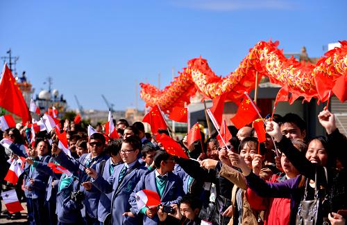 3月26日,在馬耳他瓦萊塔港,當?shù)厝A僑華人和馬耳他小學生們一起手舉中馬兩國國旗,迎接中國海軍艦艇編隊到訪。新華社記者 許逆之 攝