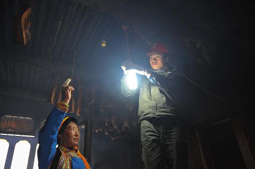 4月24日,國家電網紅巖共產黨員服務隊的隊員為磽磧藏族鄉(xiāng)受災群眾澤娘家的廚房接通了臨時照明。當日是四川省蘆山“4·20”7.0級強烈地震震后第五天,在地震重災區(qū)寶興縣最偏遠的鄉(xiāng)鎮(zhèn)之一磽磧藏族鄉(xiāng),一群電力人在各個民房之間穿梭忙碌著,他們是來自重慶的國家電網紅巖共產黨員服務隊。自4月22日進入磽磧,奮戰(zhàn)在抗震救災一線的黨員服務隊在保證當地衛(wèi)生院、政府、派出所等重點單位供電的同時,還主動深入到藏族同胞的家中,為他們排查供電線路、檢修電表、慰問受災家庭,并結合當地住戶分布情況,有選擇地分片區(qū)為當地200多戶家庭開通了臨時供電線路,方便災區(qū)藏族同胞為手機充電和家庭臨時照明。新華社記者 劉潺 攝