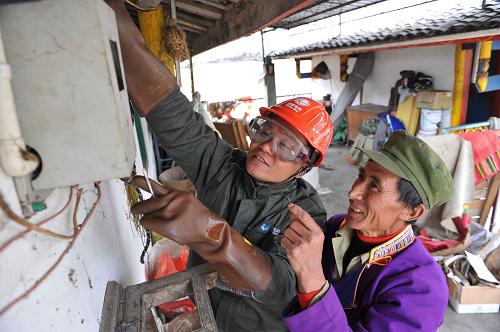 4月24日,國家電網紅巖共產黨員服務隊的隊員在為磽磧藏族鄉(xiāng)受災群眾澤娘家檢修電表,并向澤娘的丈夫60歲的阿乓(右)講解安全用電的知識。新華社記者 劉潺 攝