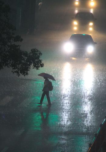 5月16日下午,廣東省汕頭市區(qū)白晝?nèi)缫?,行人頂風(fēng)冒雨出行。新華社發(fā)(姚軍 攝)
