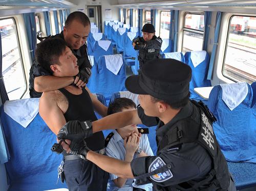 7月9日,重慶鐵路公安處特警支隊(duì)的特警隊(duì)員在硬座車廂開(kāi)展人質(zhì)劫持快速處置訓(xùn)練。新華社記者 劉潺 攝