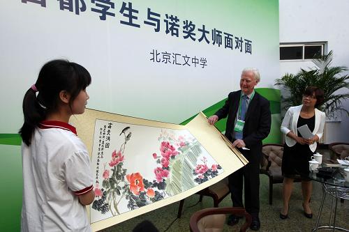 9月10日,諾貝爾經(jīng)濟學(xué)獎獲得者詹姆斯·莫里斯(右二)來到北京匯文中學(xué),獲得該校高三學(xué)生歐亞逸(左一)贈送的中國畫作品《牡丹圖》。新華社發(fā)(周良 攝)