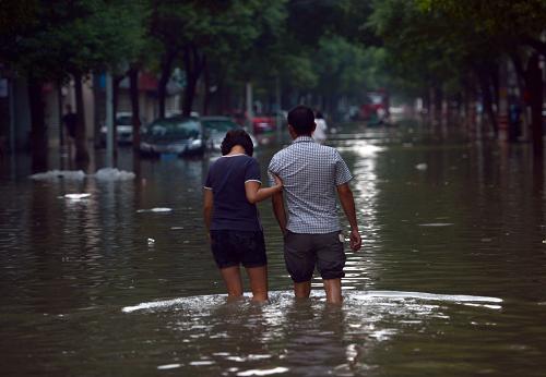 10月10日,在余姚市區(qū)一條積水道路上,人們涉水通行。記者從浙江省余姚市抗洪救災(zāi)新聞發(fā)布會獲悉,截至目前余姚城區(qū)積水區(qū)域普遍下降50公分左右,但部分地區(qū)積水依舊較深,城區(qū)積水全部退去要到到10月12日左右。盡管四天“大水圍城”沒有導(dǎo)致人員傷亡,但給余姚造成的經(jīng)濟損失初步估計超過200億元。據(jù)浙江省民政廳10日下午通報,余姚全市目前食品和飲用水供應(yīng)充足,除了政府采購的食品外,社會各界的捐贈食品和物資正在不斷運往災(zāi)區(qū)。事關(guān)百姓基本生活的水、電、路燈公共基礎(chǔ)設(shè)施也正在逐步恢復(fù)。新華社記者 韓傳號 攝