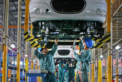 10月21日,浙江金華一家電動(dòng)車企業(yè)的工作人員在生產(chǎn)車間組裝電動(dòng)汽車。新華社發(fā)(王平 攝)
