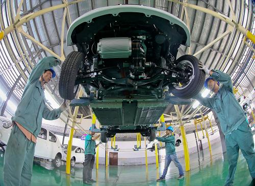 10月21日,浙江金華一家電動(dòng)車企業(yè)的工作人員在生產(chǎn)車間組裝電動(dòng)汽車。新華社發(fā)(王平 攝)