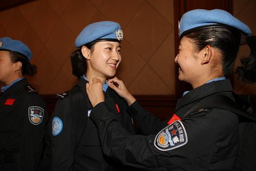 10月21日,兩名女維和警察在出發(fā)前互相整理服裝。新華社發(fā)(劉長龍 攝)