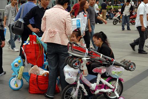 10月1日,準(zhǔn)備乘火車的旅客在上海火車站廣場(chǎng)小憩。新華社發(fā)(潘華清 攝)