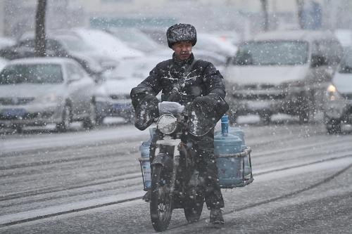 12月26日,在山東煙臺(tái)勝利路,一名送水工在雪中緩慢騎行。當(dāng)日,山東省煙臺(tái)市氣象臺(tái)發(fā)布大風(fēng)黃色預(yù)警信號(hào),受較強(qiáng)冷空氣影響,煙臺(tái)市出現(xiàn)大風(fēng)降溫降雪天氣,最低氣溫跌至零下。煙臺(tái)市海上搜救中心發(fā)布海上重大風(fēng)險(xiǎn)黃色預(yù)警,煙臺(tái)至大連、蓬萊至旅順等省際航線客船全線停航。新華社發(fā)(初陽 攝)