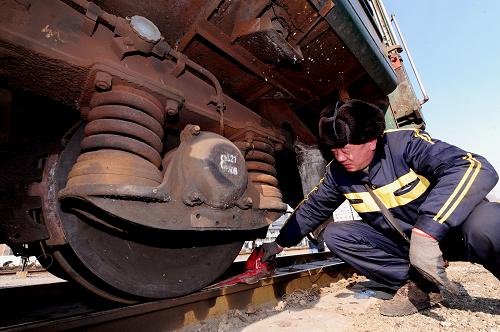 1月15日,在遼寧沈陽(yáng)火車(chē)站,一位鐵路工人在檢查列車(chē)車(chē)輪。新華社發(fā)(張文魁 攝)