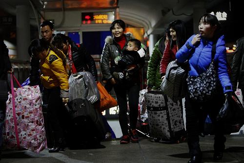 1月16日零時(shí)許,在廣州火車站,乘坐K9286次列車的乘客進(jìn)站乘車。新華社記者 邢廣利 攝
