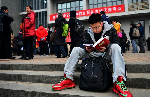 2月16日,天津南開大學(xué)考點(diǎn),一名考生在進(jìn)考場前查看復(fù)習(xí)材料。新華社發(fā)(游思行 攝)