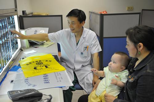 5月14日,在北京大學(xué)第一醫(yī)院,一名醫(yī)生在講解患病幼兒的復(fù)檢情況。新華社 發(fā)