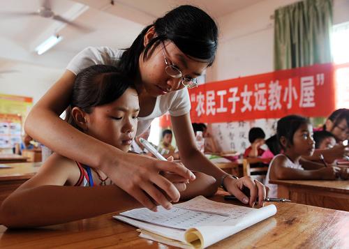 這是一名大學(xué)生志愿者在輔導(dǎo)農(nóng)民工子女學(xué)寫(xiě)硬筆書(shū)法(8月6日攝)。新華社記者 張愛(ài)林 攝