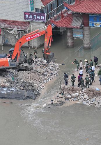8月30日,武警部隊在舟曲縣城濱江路濱河商貿(mào)城門前挖開一條約3米寬溝渠,城區(qū)內(nèi)積水開始下泄白龍江。新華社記者 梁強 攝
