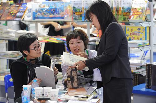 8月30日,在北京國(guó)際圖書博覽會(huì)展廳,一位展商(右一)向參觀者介紹圖書。新華社發(fā)
