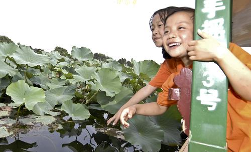 8月30日,圓明園內(nèi)的荷花讓來自舟曲的高文燕(右)、尚海嬌興奮不已。新華社發(fā)(張宇 攝)