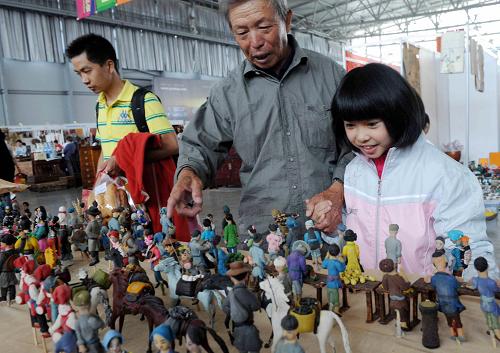 8月31日,一位老人帶著孫女在觀賞多達(dá)400多個(gè)人物的老昆明市井風(fēng)情面塑作品。新華社記者 楊宗友 攝