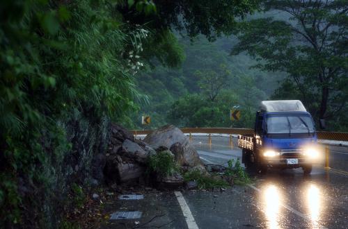 9月1日,在臺東一條盤山公路上,一輛汽車?yán)@過山上掉下來的石塊。新華社記者 費(fèi)茂華 攝