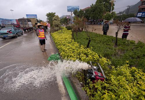 9月2日,福建省漳州市迎賓大道上出現(xiàn)大面積積水,搶險(xiǎn)救援人員運(yùn)來(lái)抽水機(jī)緊急排水。新華社記者 姜克紅 攝