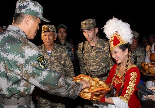 9月7日,“和平使命-2010”上海合作組織成員國武裝力量聯(lián)合反恐軍事演習(xí)中方參演部隊第一梯隊官兵抵達(dá)哈薩克斯坦南部演習(xí)地域附近的奧塔爾車站,身著節(jié)日盛裝的哈薩克斯坦姑娘向官兵們獻(xiàn)上傳統(tǒng)美食。新華社記者 王建民 攝