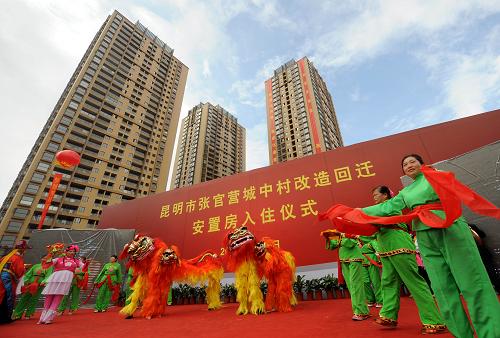 9月28日,昆明市張官營的居民在回遷安置房入住儀式上表演節(jié)目,背后的高樓就是他們的新居。當(dāng)日,云南省昆明市首個(gè)“城中村”回遷安置房張官營正式落成入住,500多戶村民搬進(jìn)新居。張官營位于昆明市盤龍區(qū)聯(lián)盟街道辦事處,曾經(jīng)是一個(gè)治安問題嚴(yán)重的地區(qū)。2008年,昆明市政府開始了張官營“城中村”改造項(xiàng)目,按照“政府主導(dǎo)、企業(yè)參與、村民自愿”的工作原則和“先安置、先搬遷、后拆遷”及公益項(xiàng)目先行的運(yùn)作模式,保證了村民在改造過程中有房可住。如今,新建的回遷安置房占地18.6畝,地上建筑物總面積7.2萬平方米,配備了學(xué)校、幼兒園及花園、綠地和健身設(shè)施等,一個(gè)現(xiàn)代化的小區(qū)讓村民們樂在其中。據(jù)了解,今年昆明市的“城中村”改造把回遷安置房建設(shè)作為重點(diǎn),其目標(biāo)不少于800萬平方米。新華社記者 藺以光 攝