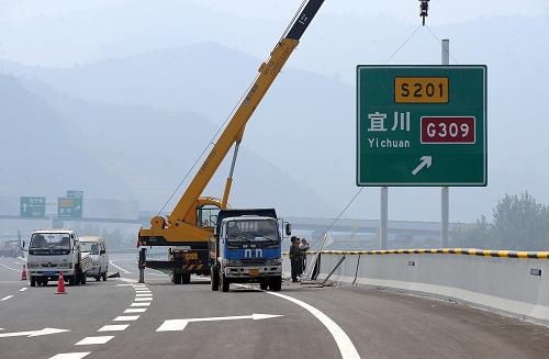 10月18日,施工人員正在青(島)蘭(州)高速公路陜西段安裝路標(biāo),為通車做準(zhǔn)備。新華社記者 陶明 攝